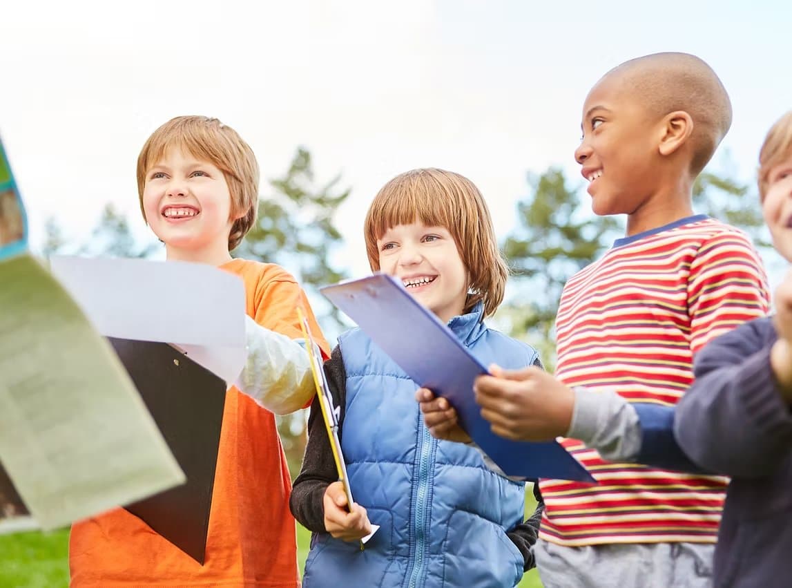 Kids participating in an outdoor group activity with clipboards
